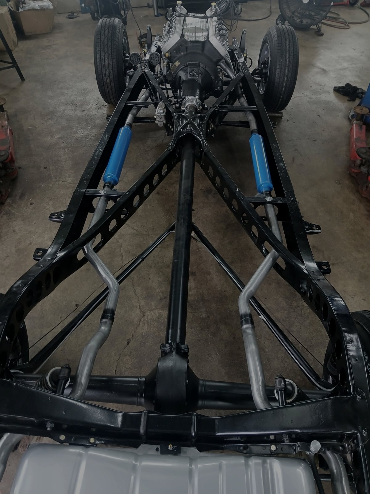 Restored truck chassis with new suspension and exhaust piping in the shop